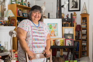 woman standing and smiling amid artwork