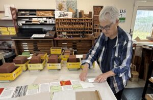 woman folding artists book sheets