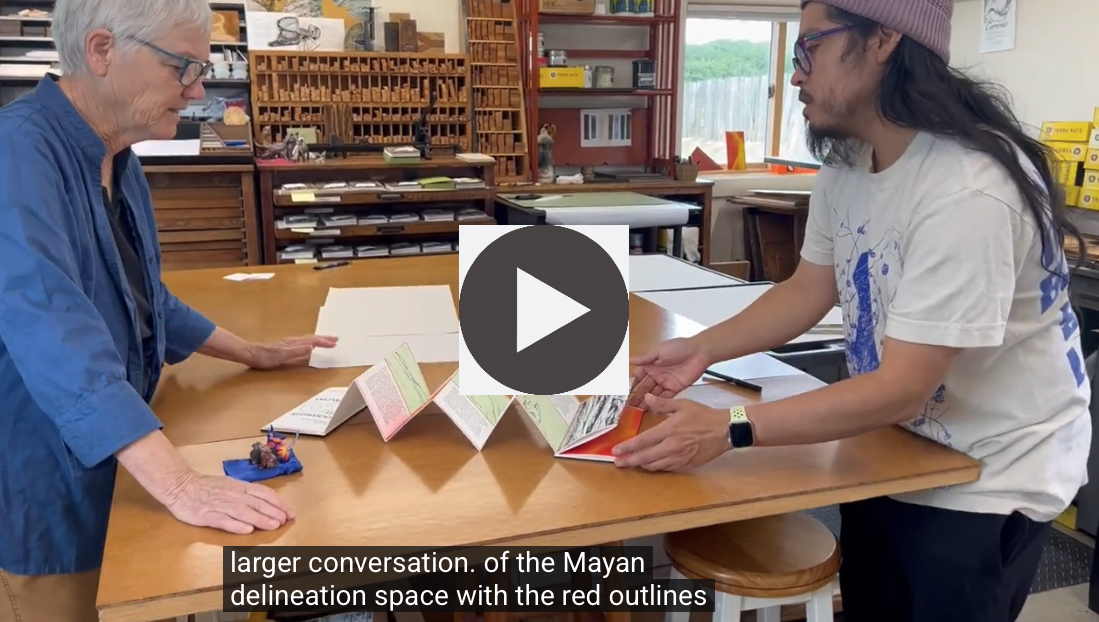 man and woman talk about book on table