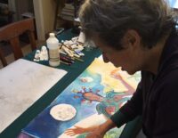 woman painting her artists' book spread