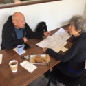 man and woman seated across table with papers