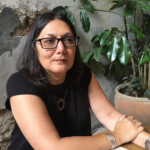 Laura Pérez, curator and editor woman seated at table